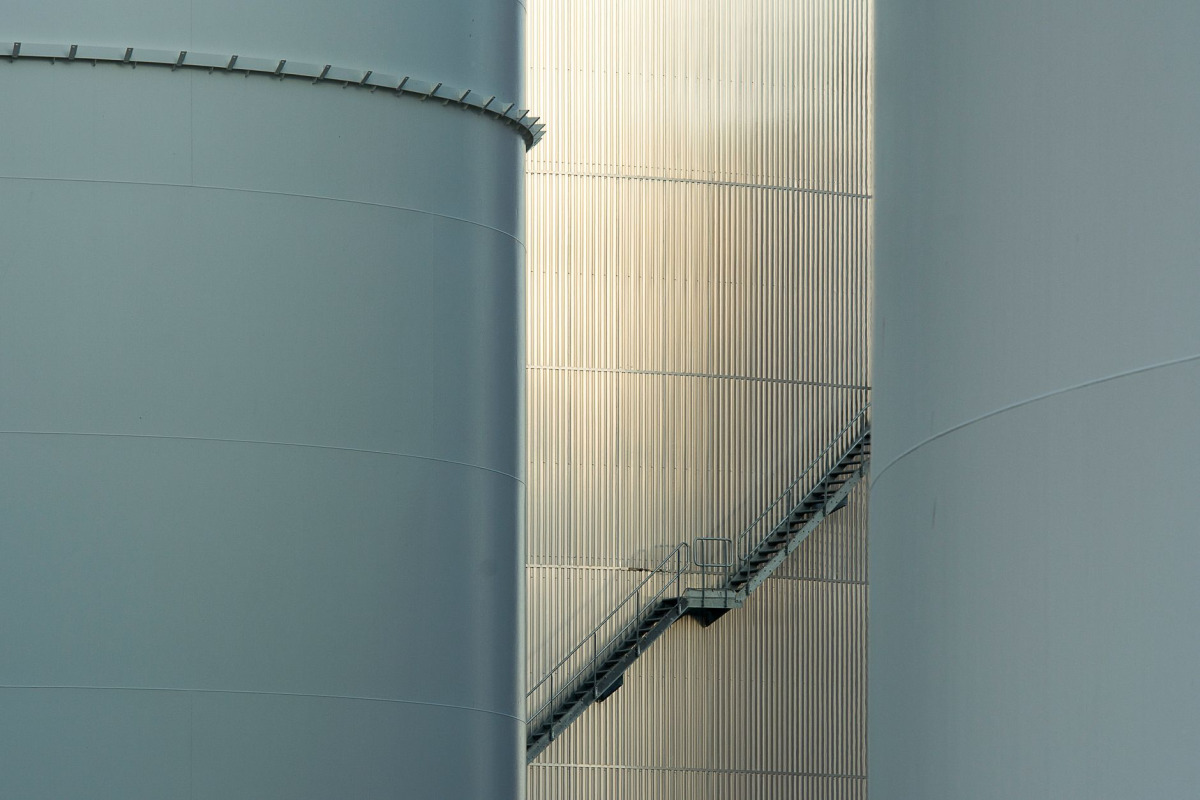 Close-up of tall industrial storage tanks featuring exterior stairs and a modern design.